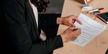 Mujer heredera firmando la declaración de la Renta de un familiar fallecido en una mesa de oficina