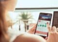 Mujer consultando la app de Airbnb en su móvil: alerta sobre el timo del cupón fantasma que reaparece cada verano